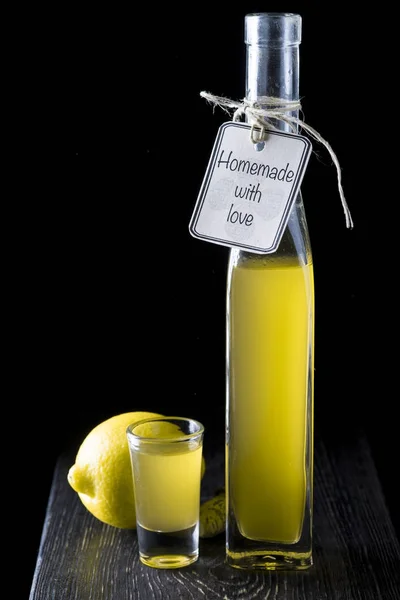 Італійський limoncello у чарку на чорному тлі дерев'яні — стокове фото