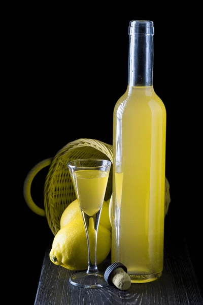 Italský limoncello ve sklenici zastřelených na černém pozadí dřevěná — Stock fotografie