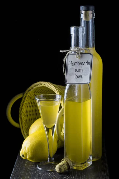 Італійський limoncello у чарку на чорному тлі дерев'яні — стокове фото