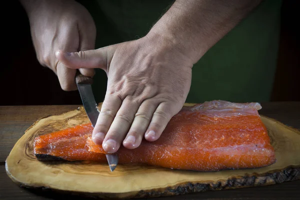 Нарезание гравянкового лосося ножом — стоковое фото