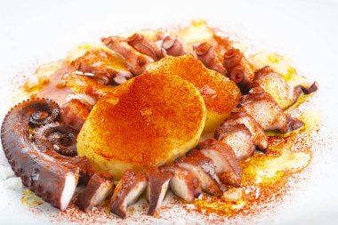 Pişmiş ahtapot tentalsı beyaz bir arkaplanda izole edilmiş ve dekore edilmiş.