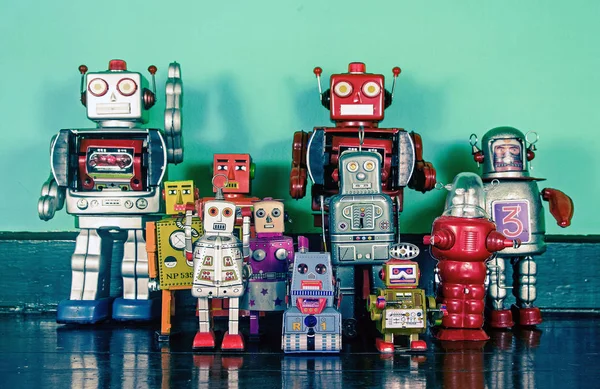 En gruppe retro-roboter på et tregulv – stockfoto