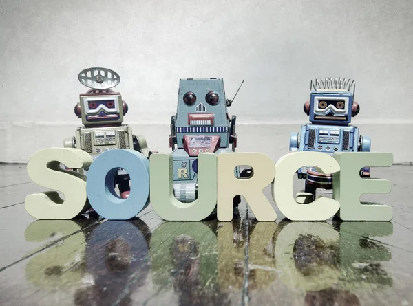 Team of robots and the word source — Stock Photo, Image