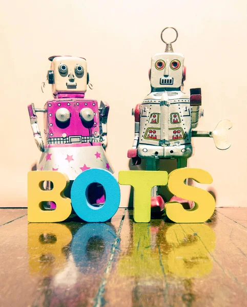 Due giocattoli robot retrò e la parola BOTS — Foto Stock