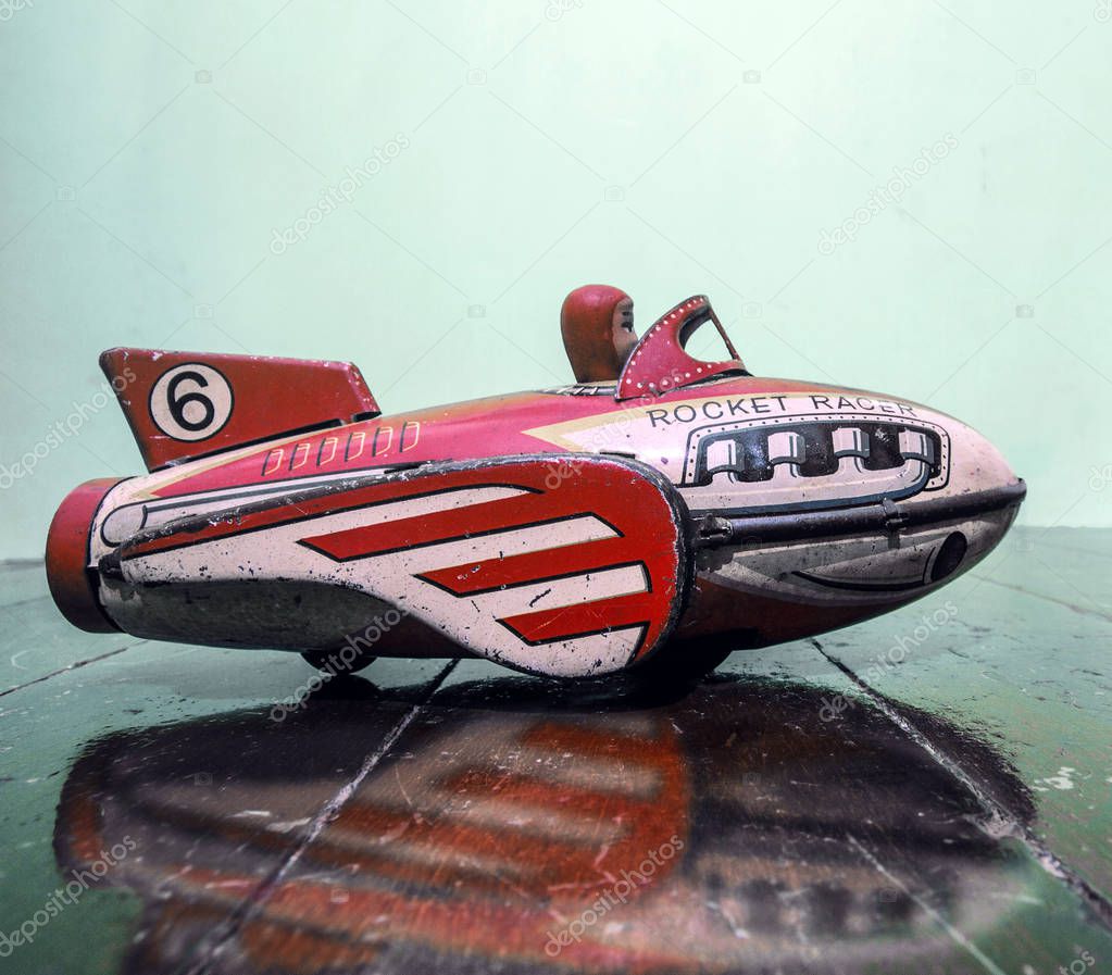 retro rocket tin toy close up on a wooden floor 