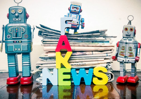 Tři Retro Roboti Hromada Starých Novin Slovem Fake News Dřevěné — Stock fotografie