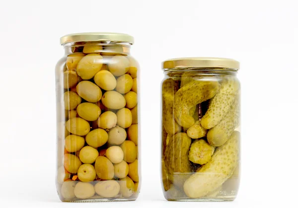 Gläser mit Essiggurken und Oliven auf weiß — Stockfoto