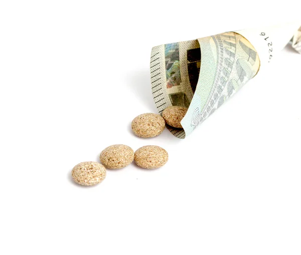 Трав'яні медичні таблетки та банкнота євро на білому тлі . — стокове фото