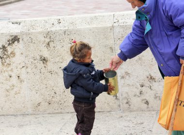 Skopje, Makedonya - 18 Ekim 2016: yaşlı kadın Üsküp, Makedonya'nın başkenti şirin dilenci kız şehir merkezine para verir