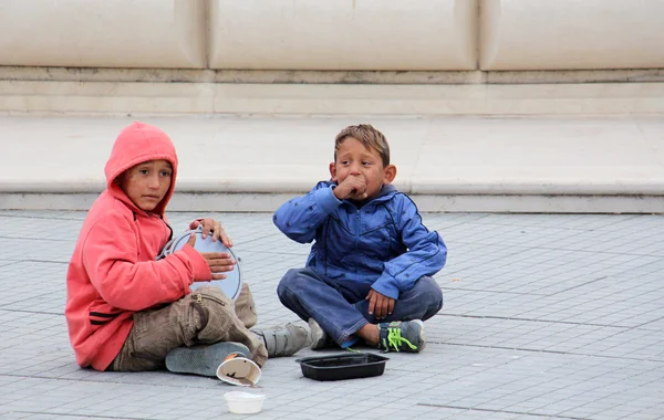 SKOPJE, MACEDONIA - 18 DE OCTUBRE DE 2016: Niño gitano cantando y jugando darbuka pidiendo dinero en el centro de Skopje, capital de Macedonia — Foto de Stock