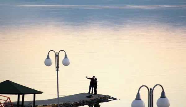 Paar overneemt selfy op een pier op een Prespameer in macedonia.sunset meer . — Stockfoto
