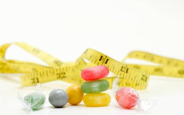 renkli meyve tadı şeker. ve şerit metre tutmayi gıda kavramı