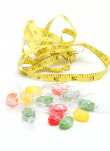 Die farbigen Früchte schmecken Bonbons. und Maßband .sweet food concept — Stockfoto