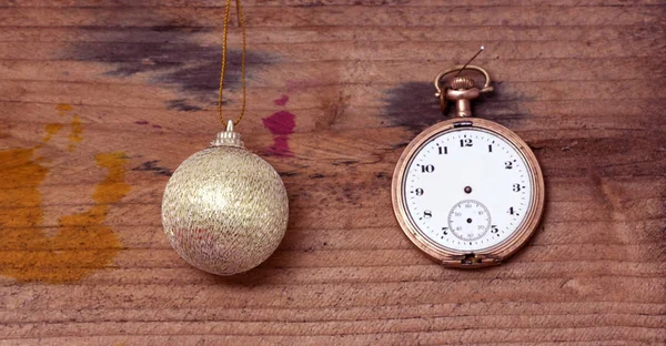 Relógio de bolso vintage e bola de Natal no fundo de madeira — Fotografia de Stock