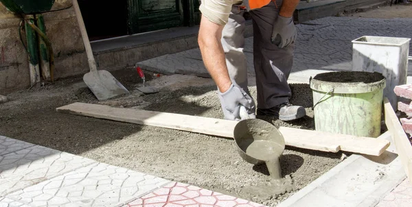 Worker pouring cement for pavement instalation — Stock Photo, Image