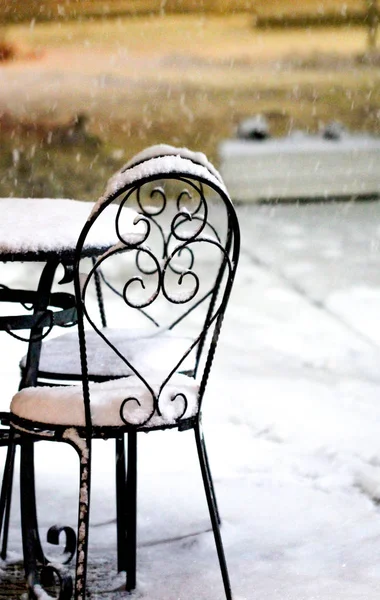 Krzesła i stół w caffe na zewnątrz na snowy zimna noc — Zdjęcie stockowe