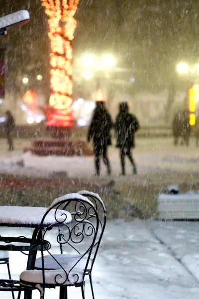 Stolar och bord i utomhus caffe snöig kall natt — Stockfoto