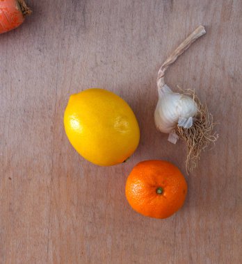 sarımsak, portakal ve limon ahşap arka plan üzerinde