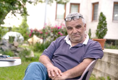 Üst düzey arka bahçesinde bir sandalyede oturan rahat