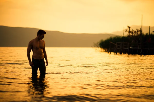 Muscolo bagnato sexy giovane ragazzo in posa nel lago — Foto Stock