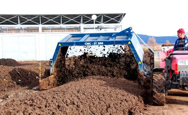 RESEN, MACEDONIA - MARCH 6, 2017: Tractor mixing manure,organic waste and soil for producing high quality compost on the producing plant near city of Resen, Macedonia