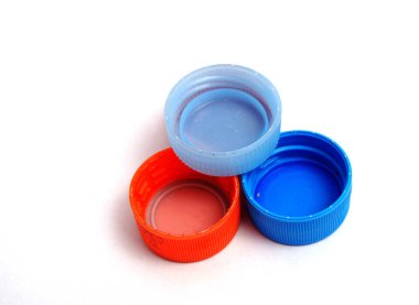 Beyaz arka plan üzerinde plastik şişe kapakları. seçici odak