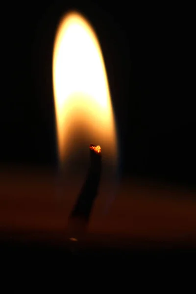 Hořící svíčka na černém pozadí — Stock fotografie