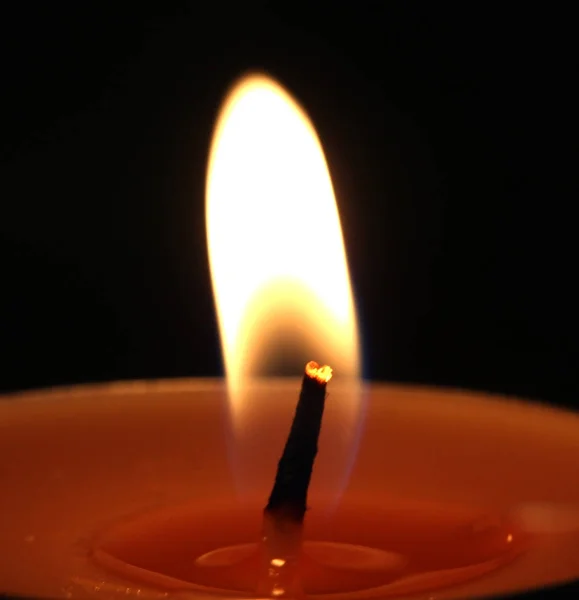 Hořící svíčka na černém pozadí — Stock fotografie