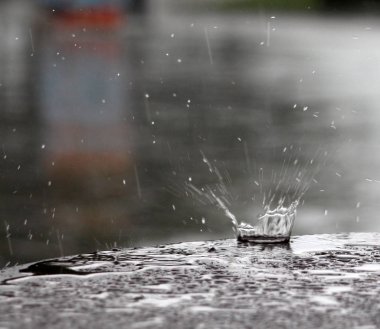 bir masa yüzeyine düşen yağmur damlaları