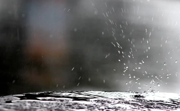 Gotas de chuva caindo em uma superfície de mesa — Fotografia de Stock