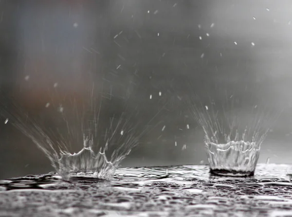 Капли дождя, падающие на поверхность стола — стоковое фото