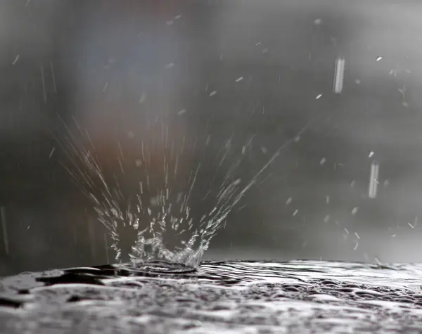Gotas de lluvia cayendo sobre una superficie de mesa —  Fotos de Stock