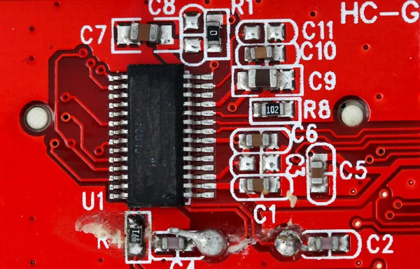 Tiro macro de uma placa de circuito laranja ou vermelha danificada velha — Fotografia de Stock