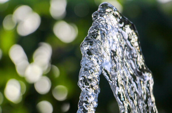 Свежая вода течет из шланга на фоне размытия
