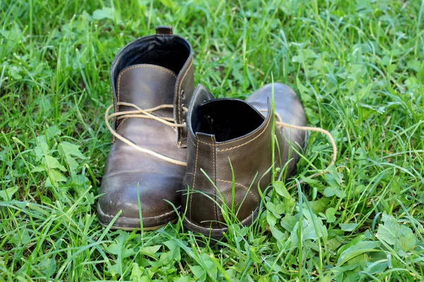 Las botas calientes de cuero de los hombres sobre el fondo de hierba — Foto de Stock