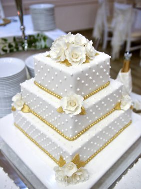 Masadaki beyaz düğün pastası.