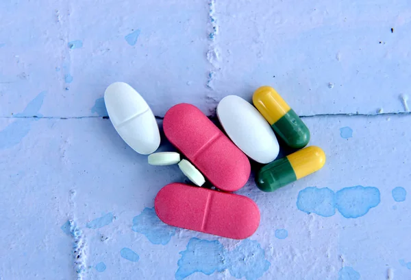 Pillole colorate, capsule su sfondo blu — Foto Stock