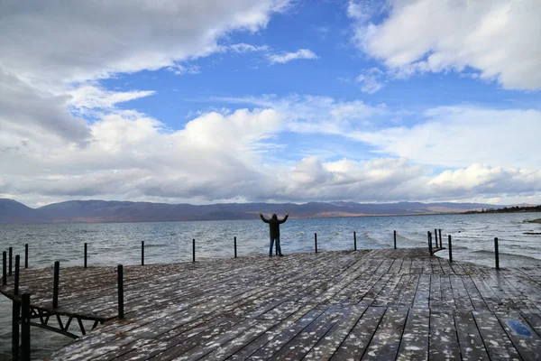 Freiheit feiern. positive menschliche Emotionen, Lebenswahrnehmung, Erfolg, Seelenfrieden-Konzept. Mann auf einem Steg. Lake Prespa, Mazedonien — Stockfoto