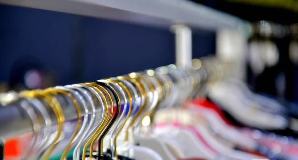 Roupas penduradas em um rack de roupas em boutiquea — Fotografia de Stock