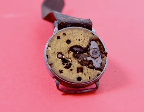 Mecanismo de relógio velho enferrujado no fundo vermelho — Fotografia de Stock