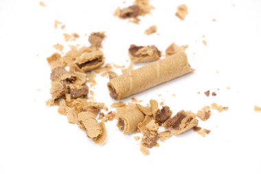 beyaz zemin üzerine çikolata sos dolu gofret haddelenmiş,