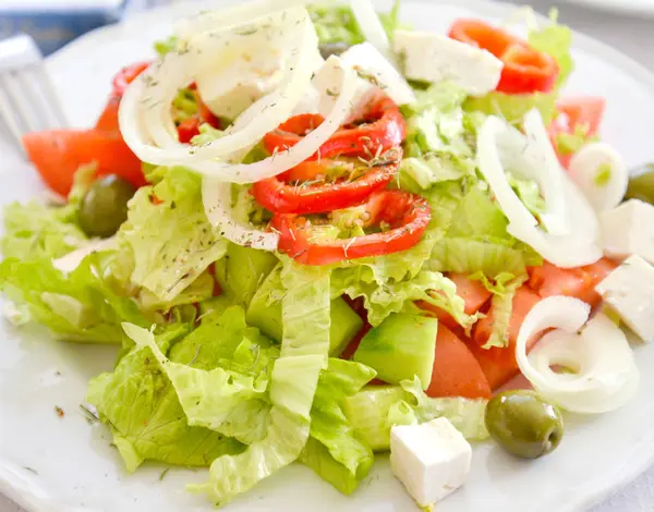 Frisch zubereiteter griechischer Salat auf weißem Teller — Stockfoto