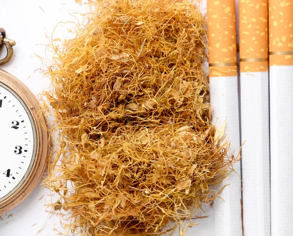 Cigarrillos y tabaco en el fondo blanco, concepto de adicción — Foto de Stock