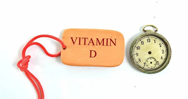 Vintage klok en kleine kleiplaat met tekst vitamine d — Stockfoto