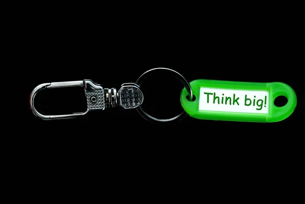 Schlüsselanhänger und grüner Etikettenhalter mit Text, groß denken — Stockfoto