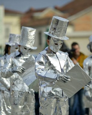 Prilep, Makedonya. 18 Şubat 2018 - Makedonya 'nın Prilep kentinde düzenlenen yıllık uluslararası karnaval Prochka 2018, alüminyum folyoyla sarılı tanınmayan bir adam, elinde kitap tutuyor.