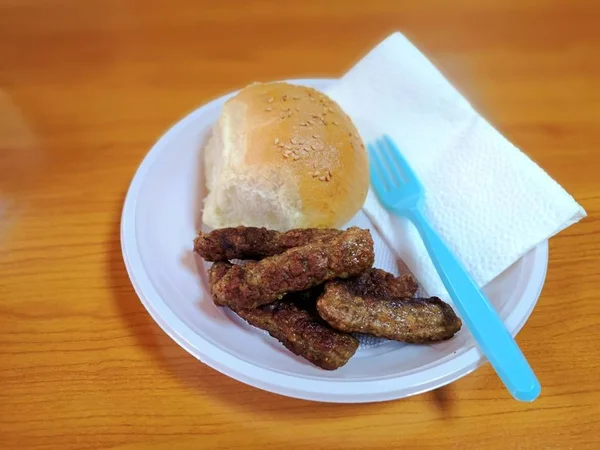 Kebap e pão com sementes de gergelim em uma placa descartável — Fotografia de Stock