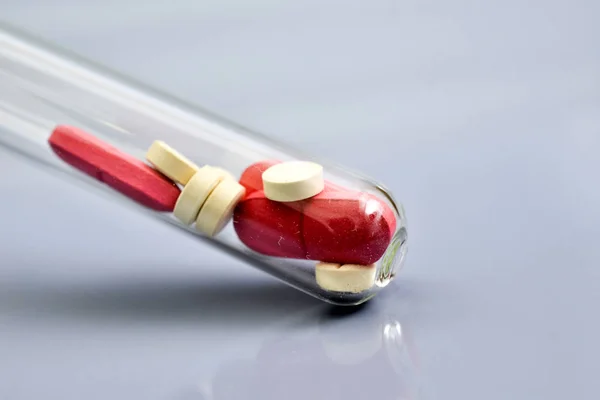 Κόκκινα και λευκά χάπια σε σκονισμένο δοκιμαστικό σωλήνα — Φωτογραφία Αρχείου