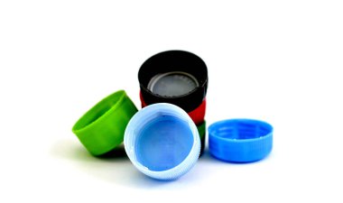 Beyaz arka planda çeşitli kirli şişe kapakları.