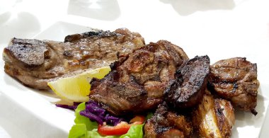 Ahşap tabakta çeşitli ızgara etler.